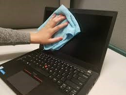 Limpiando ordenador portátil con un pañuelo por fuera la pantalla